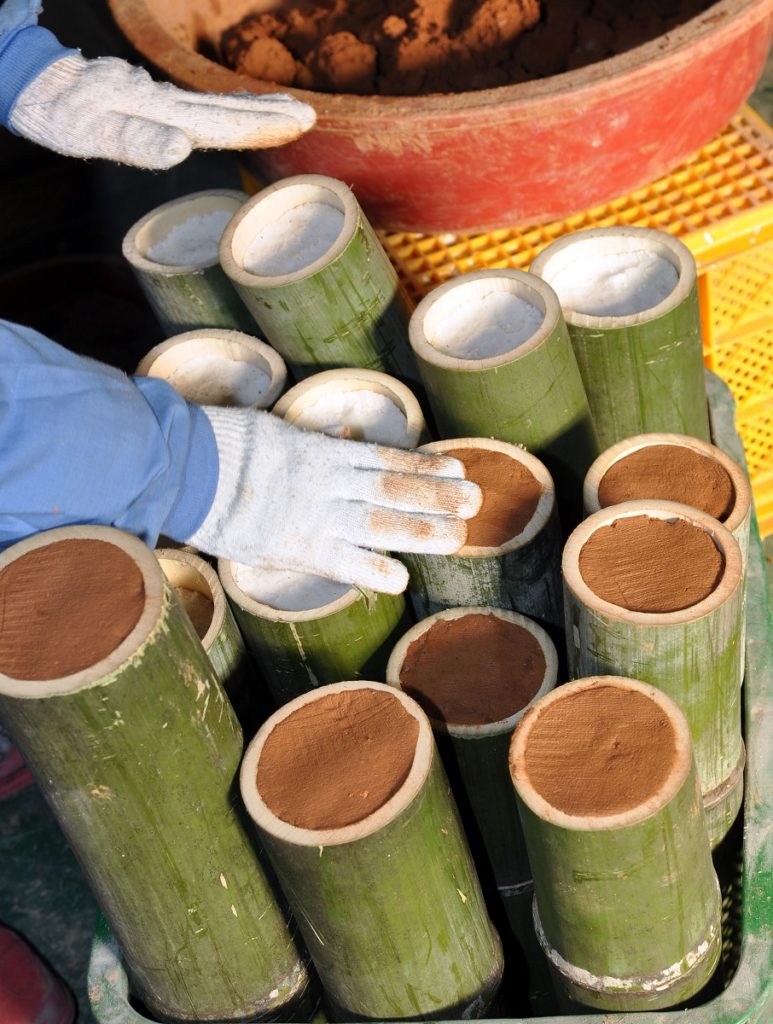 Mit Meersalz befüllter Bambus wird mit rotem Ton versiegelt