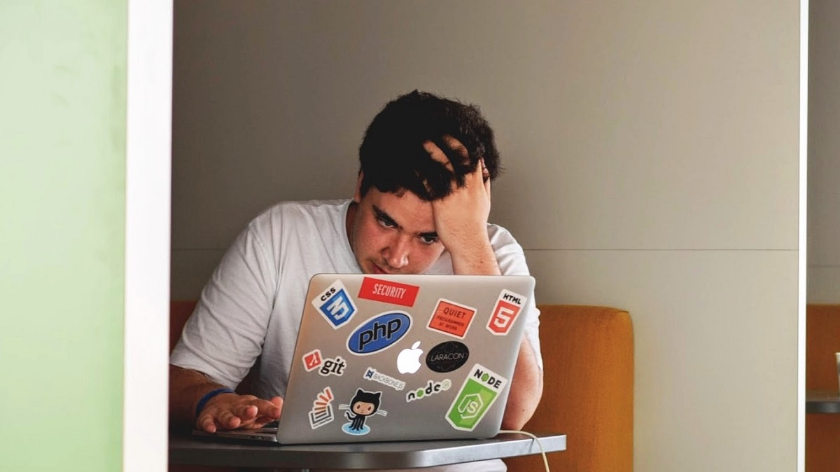Tired man behind laptop due to loss of body fluid