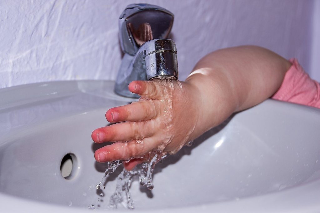 kinderhandje onder een kraan op school met misschien wel loden leidingen