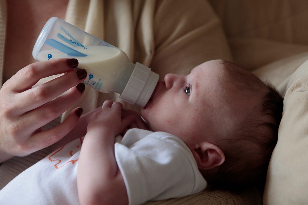 Bébé recevant son biberon préparé à partir d'une bonne eau en bouteille telle que la Pineo