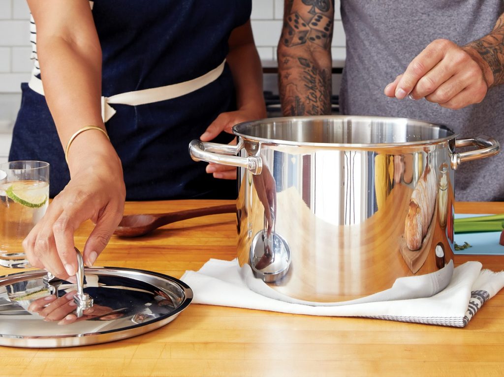 two people cooking with hot water from the tap