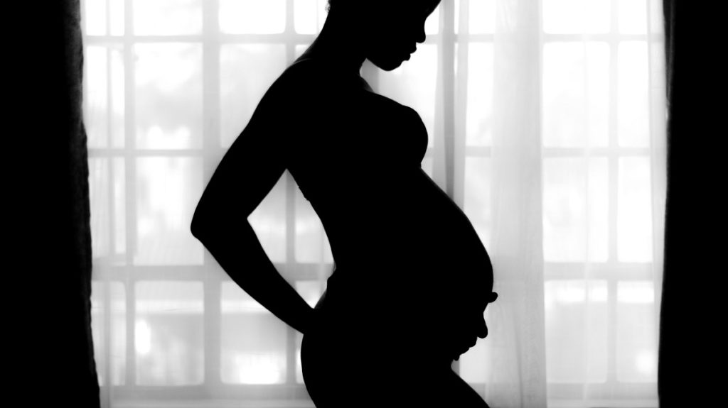 zwangere vrouw die kokosolie gebruikt als prenatale voeding