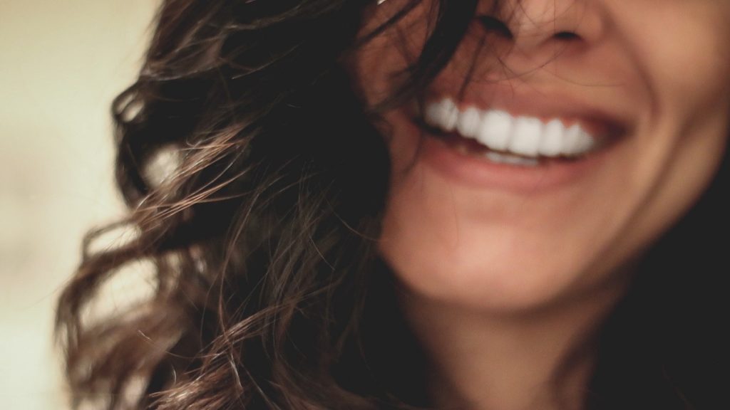 une femme avec beau sourire blanc grâce aux bains de bouche à l'huile de coco et du vinaigre de pomme avec la mère