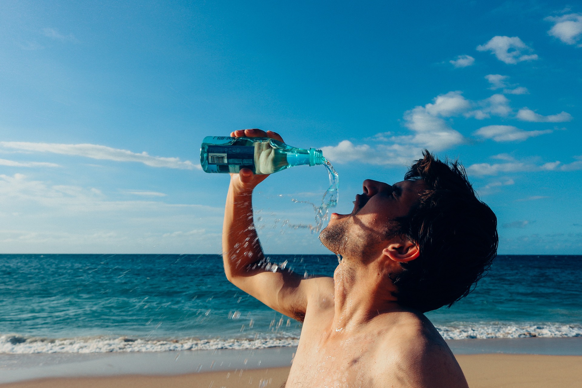 Mann trinkt Wasser nach dem Training